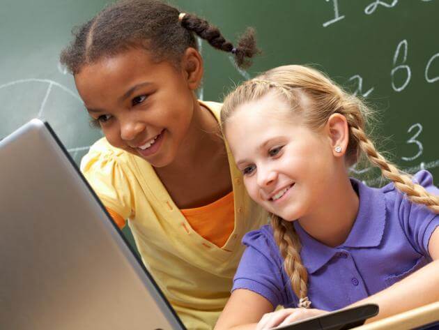 two girls looking at a laptop